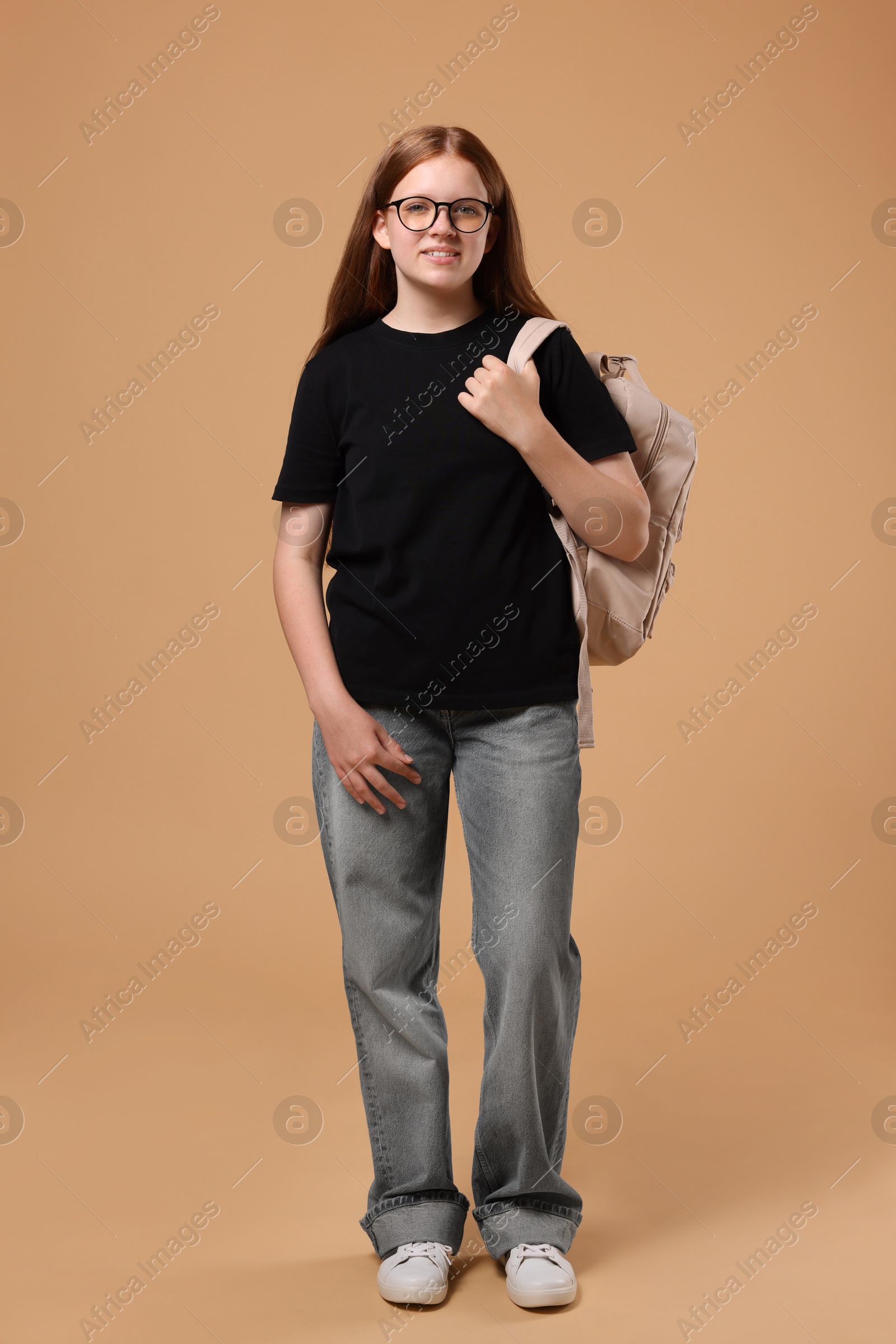 Photo of Teenage girl with backpack on beige background