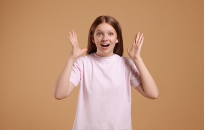 Portrait of teenage girl on beige background, space for text