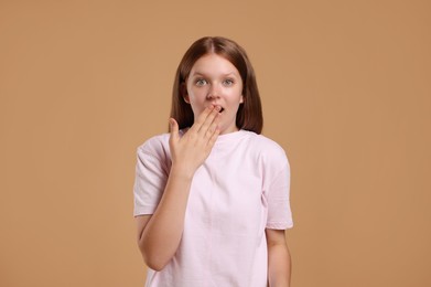 Portrait of teenage girl on beige background, space for text