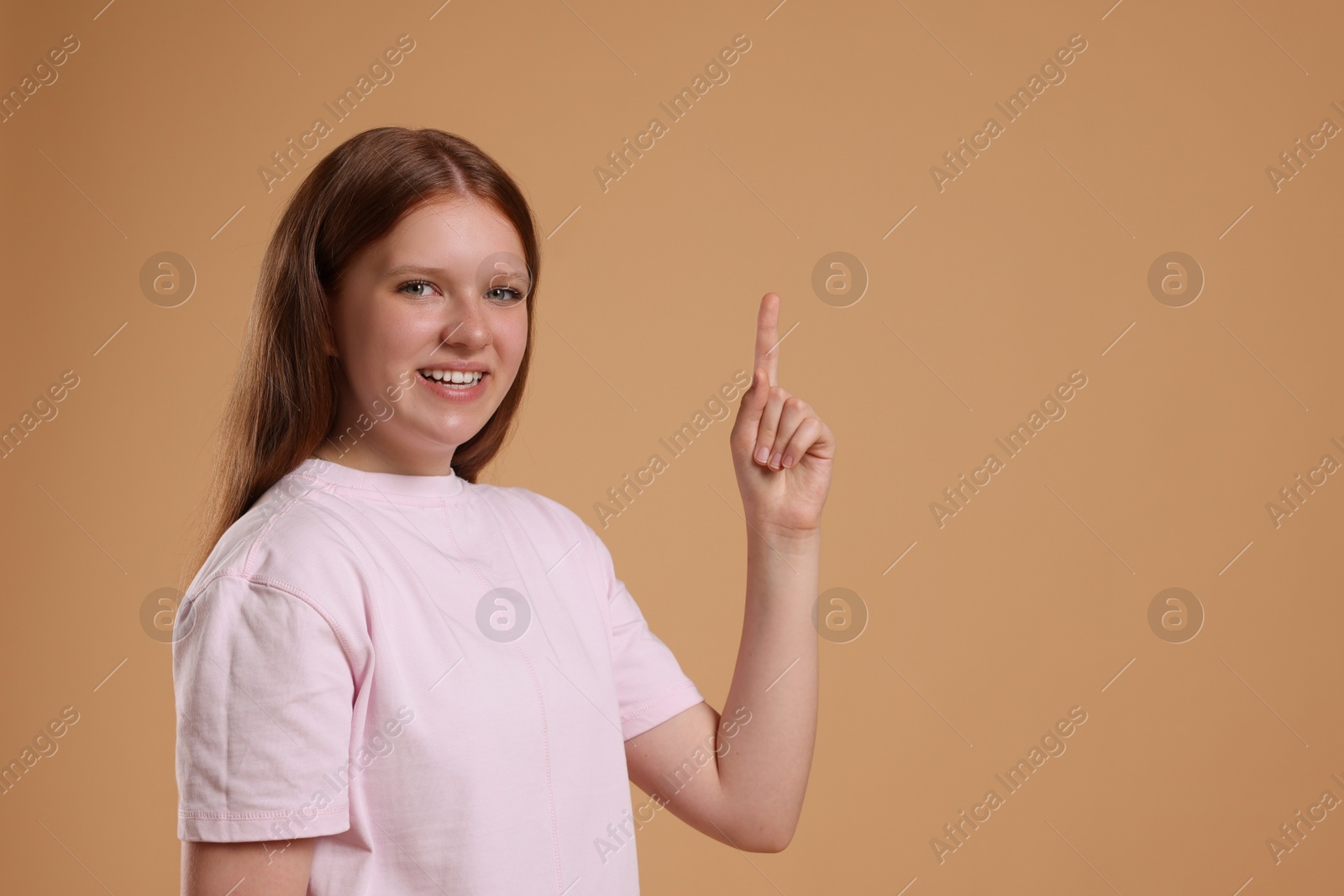 Photo of Portrait of teenage girl on beige background, space for text