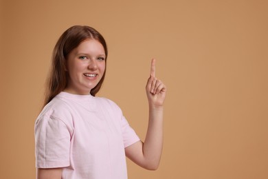 Portrait of teenage girl on beige background, space for text