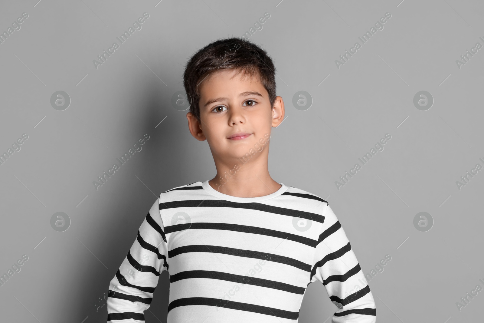 Photo of Portrait of cute little boy on grey background