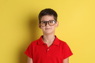 Photo of Portrait of cute little boy on yellow background