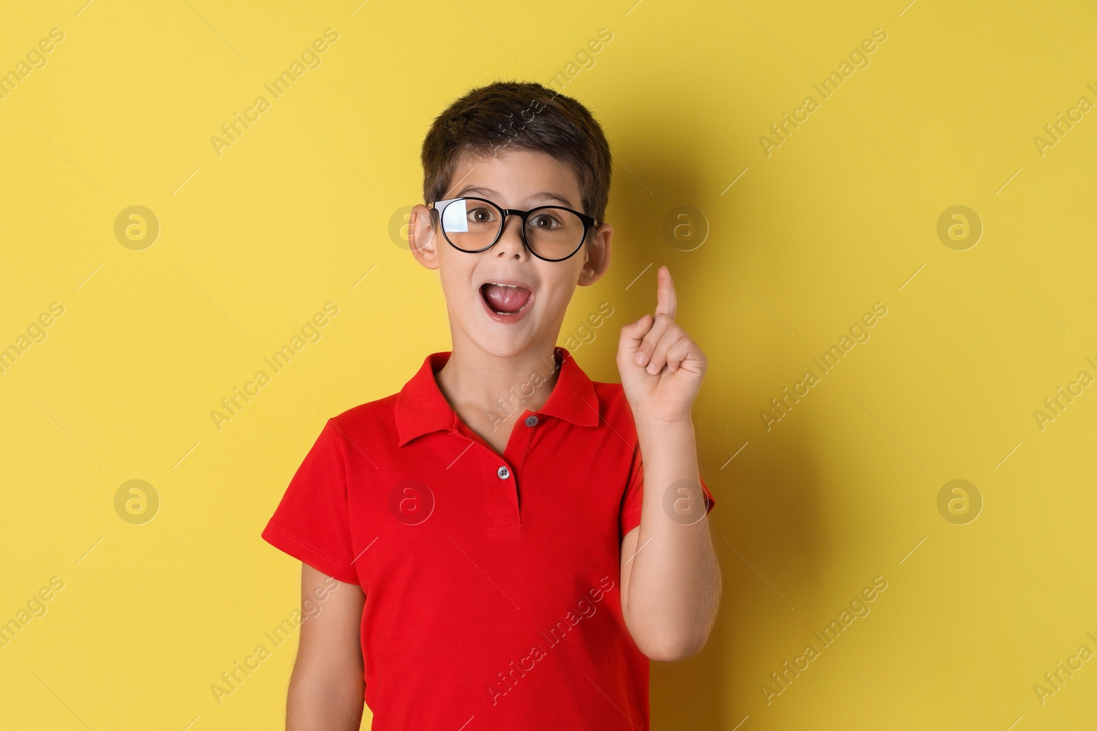 Photo of Portrait of cute little boy on yellow background