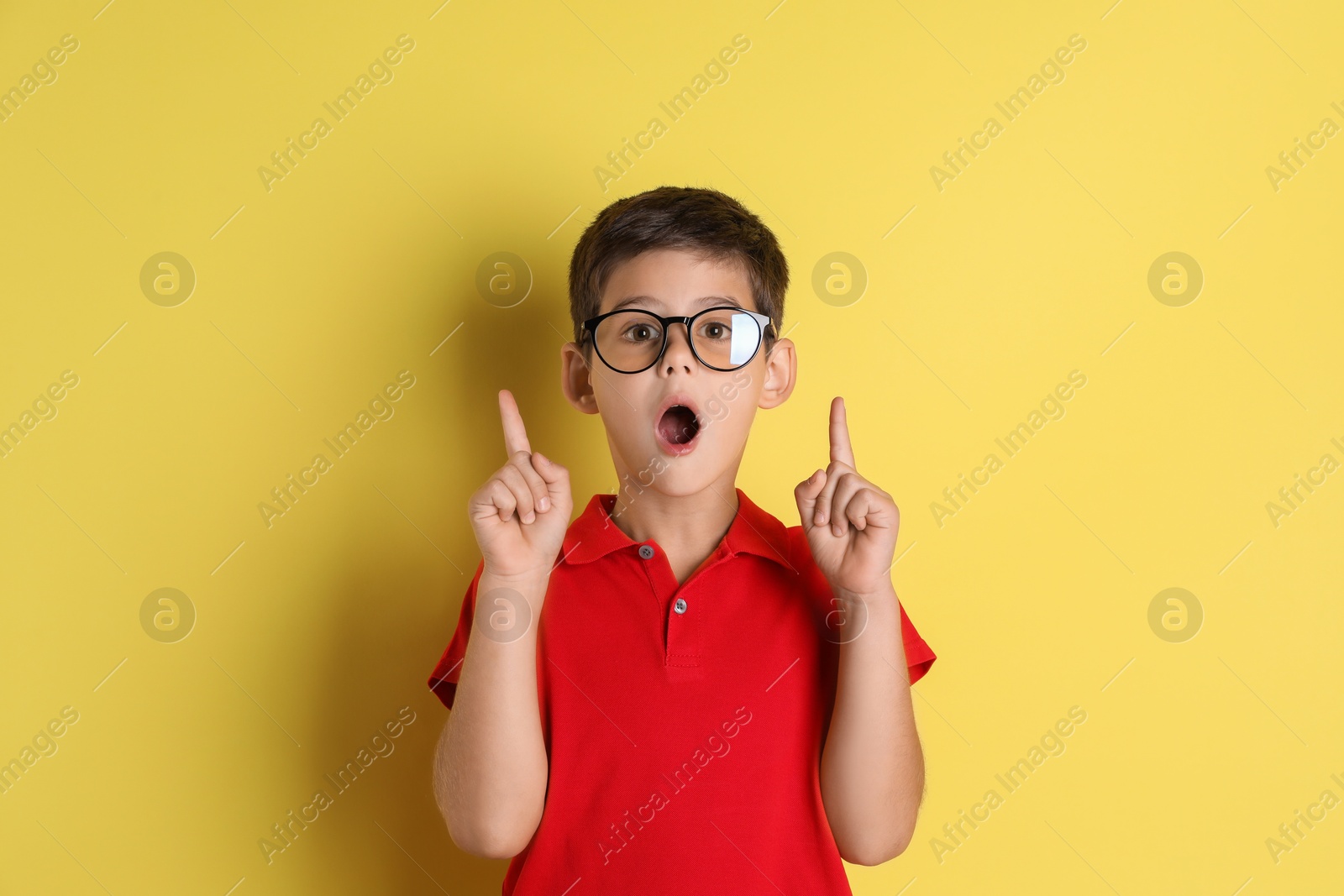 Photo of Portrait of cute little boy on yellow background