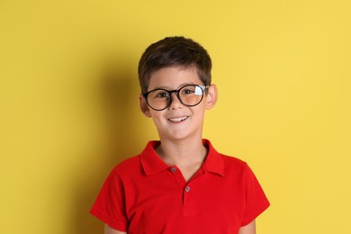 Photo of Portrait of cute little boy on yellow background