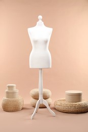 One female mannequin, poufs and boxes on beige background