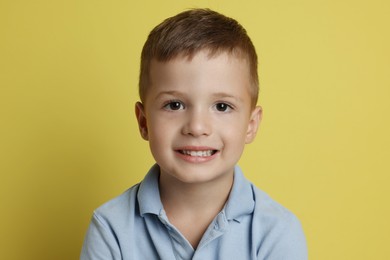 Portrait of cute little boy on yellow background