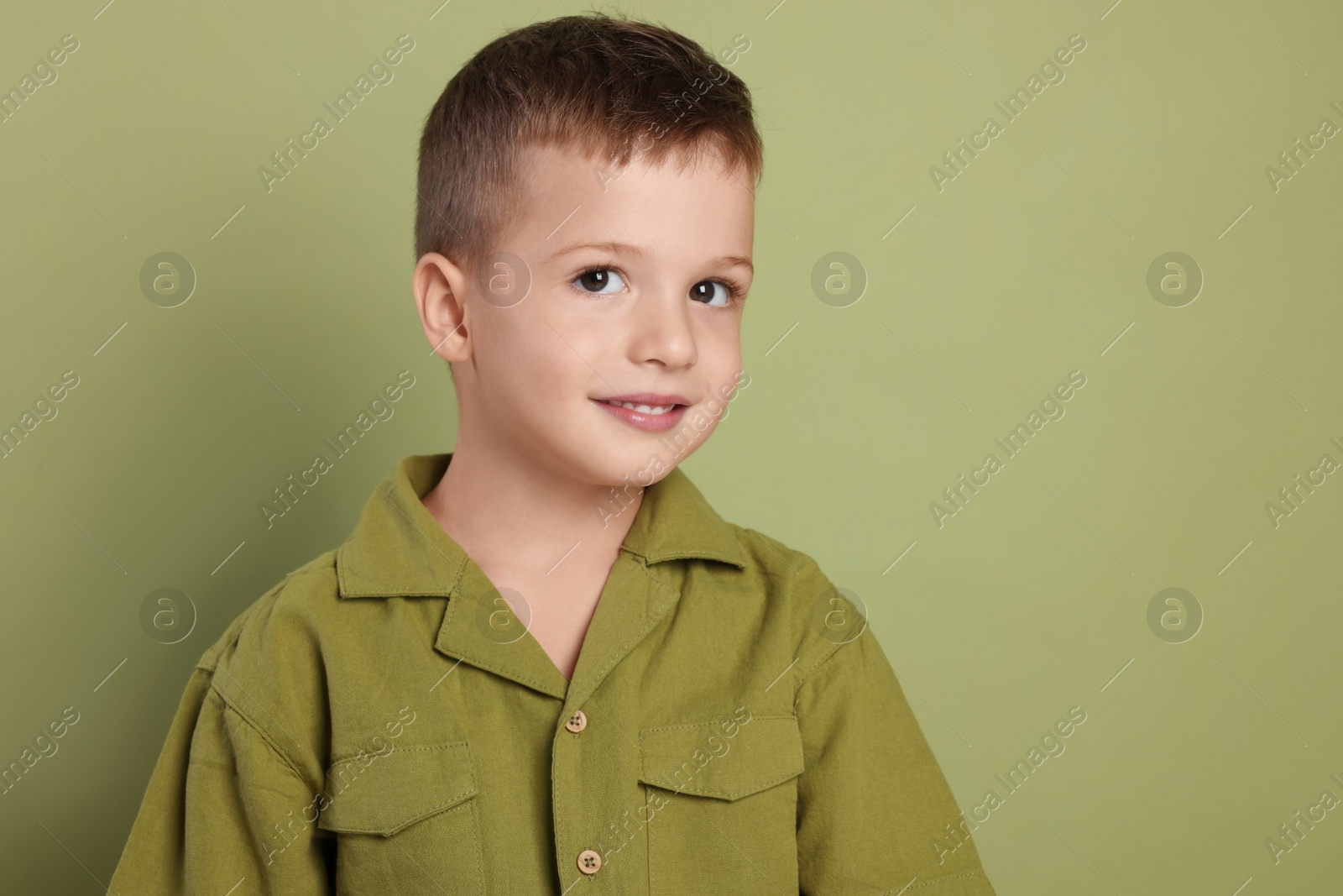 Photo of Portrait of cute little boy on green background