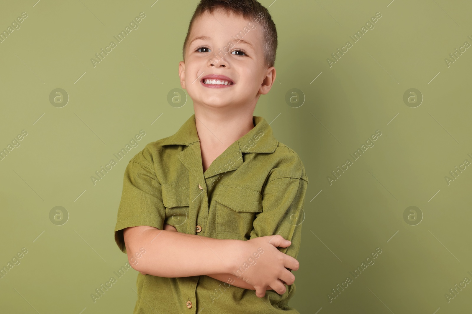 Photo of Portrait of cute little boy on green background