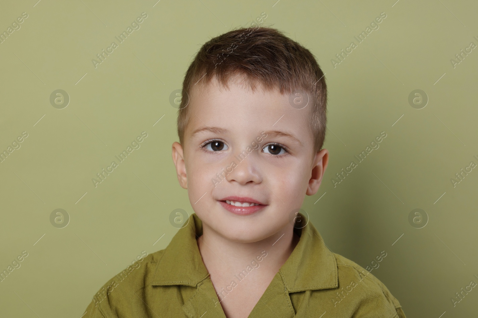 Photo of Portrait of cute little boy on green background