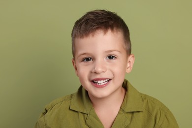 Photo of Portrait of cute little boy on green background