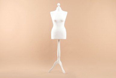 One stylish female mannequin l on beige background