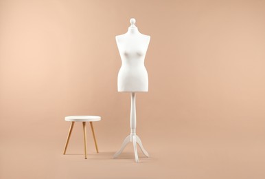 Photo of Female mannequin and stool on beige background