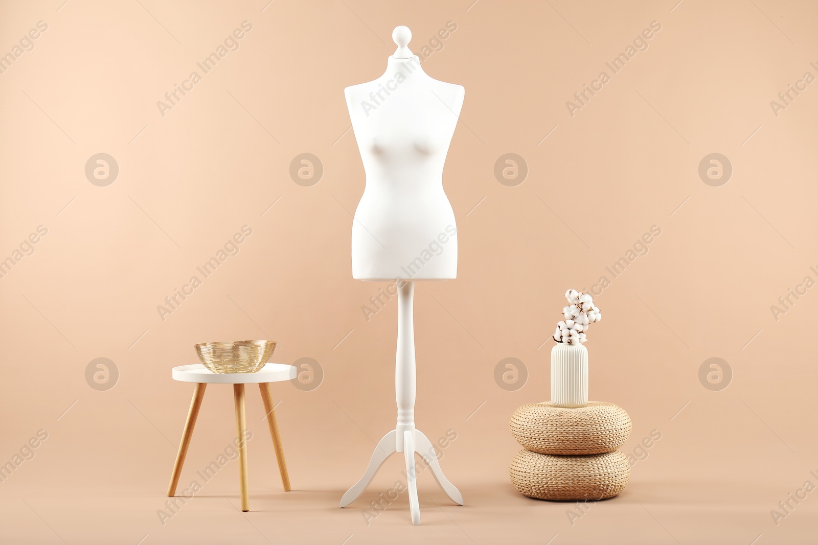 Photo of Female mannequin and vase on beige background