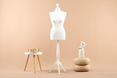 Photo of Female mannequin and vase on beige background