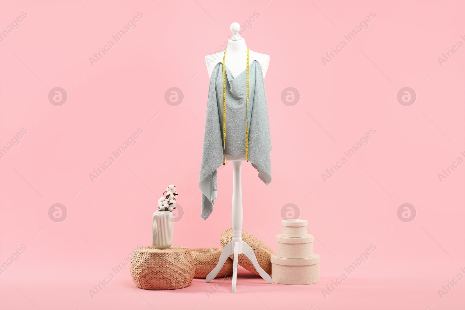 Photo of Mannequin, cloth and measuring tape on pink background