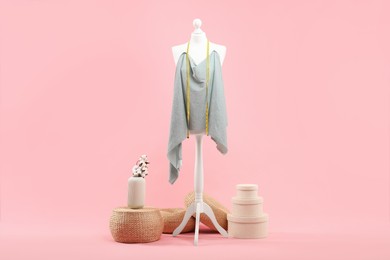 Photo of Mannequin, cloth and measuring tape on pink background