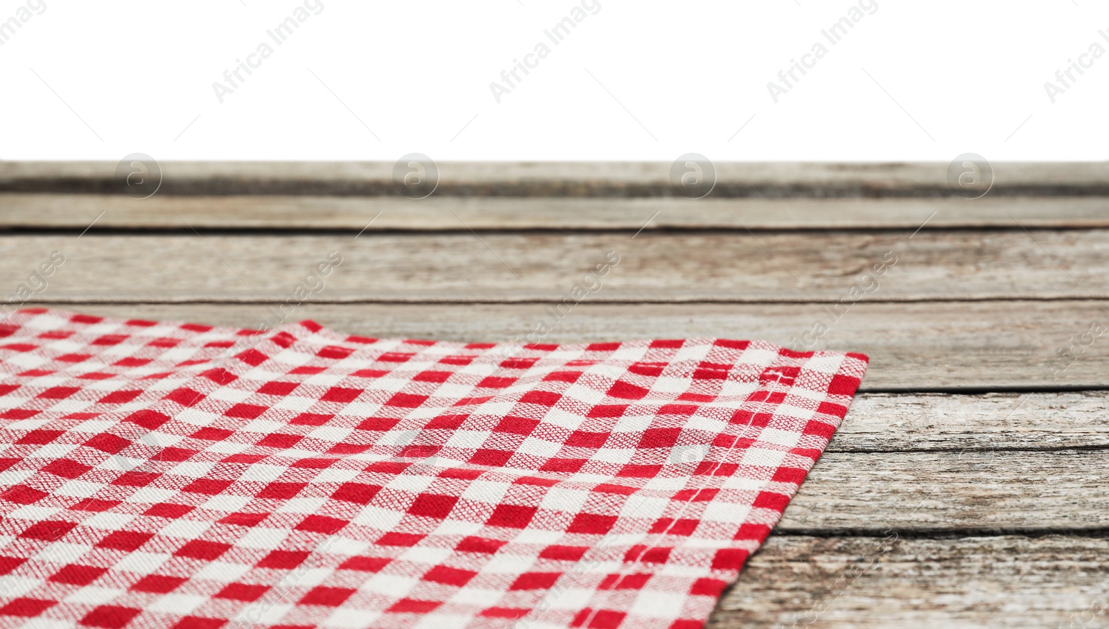 Photo of Tablecloth with checkered pattern on wooden table against white background