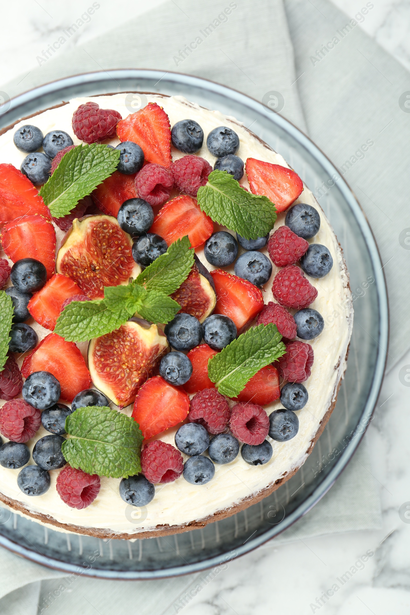 Photo of Delicious chocolate sponge cake with berries on white table, top view