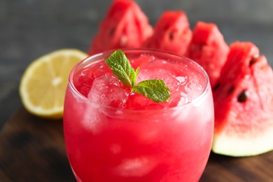 Photo of Tasty watermelon drink in glass on blurred background, closeup