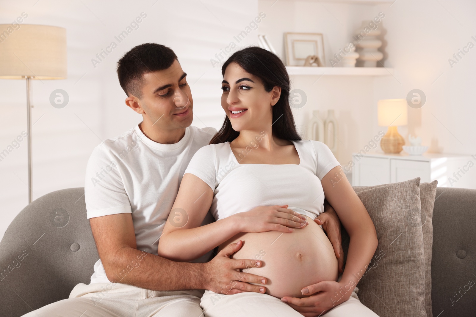 Photo of Beautiful pregnant woman spending time with her husband at home