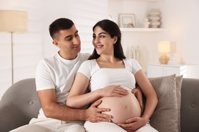 Photo of Beautiful pregnant woman spending time with her husband at home