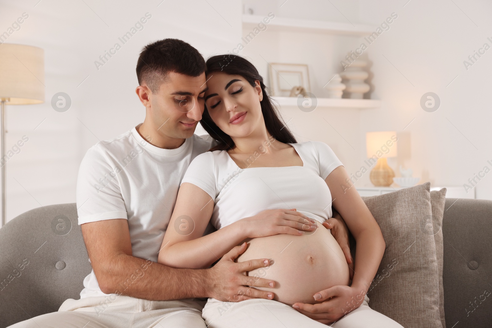 Photo of Beautiful pregnant woman spending time with her husband at home