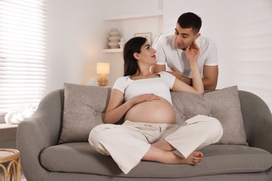 Beautiful pregnant woman spending time with her husband at home