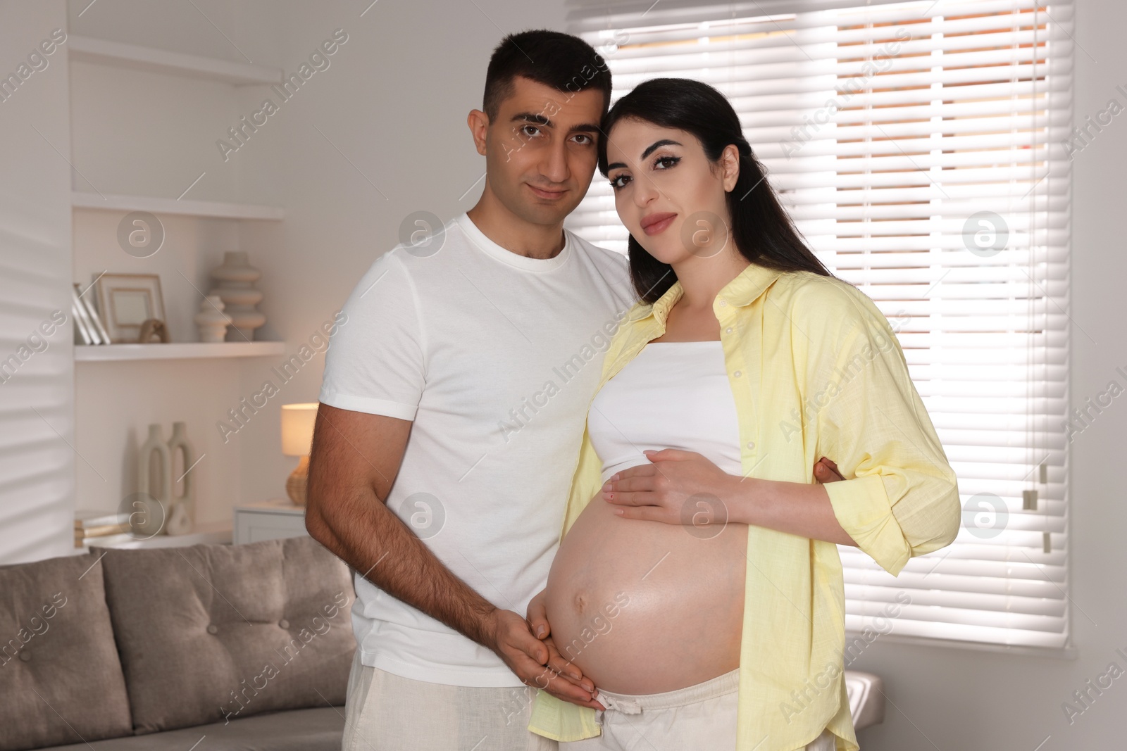 Photo of Beautiful pregnant woman with her husband at home