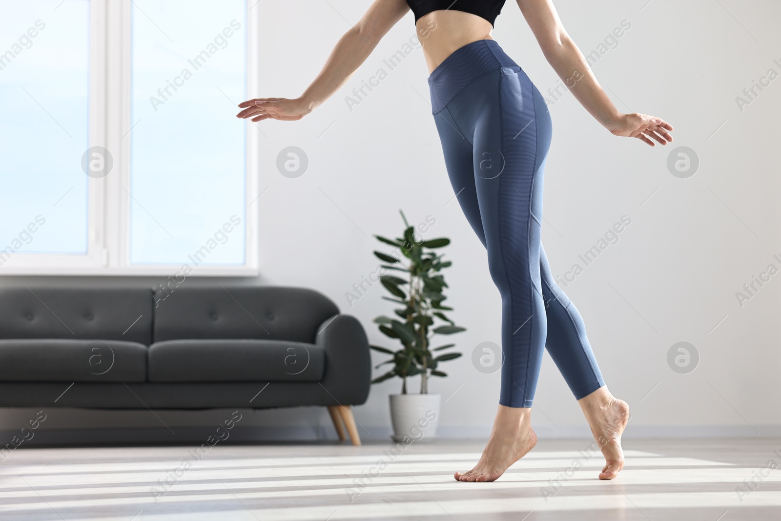 Photo of Woman wearing blue sports leggings in room, closeup