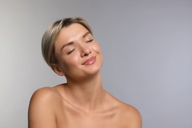 Cosmetology. Beautiful woman with perfect skin on grey background