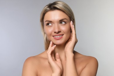 Photo of Cosmetology. Beautiful woman with perfect skin on grey background