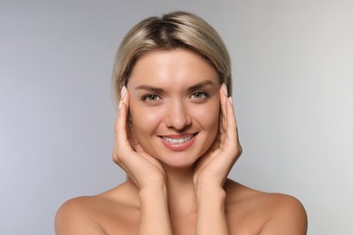 Cosmetology. Beautiful woman with perfect skin on grey background