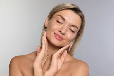 Cosmetology. Beautiful woman with perfect skin on grey background