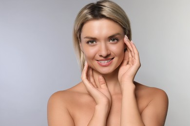 Cosmetology. Beautiful woman with perfect skin on grey background