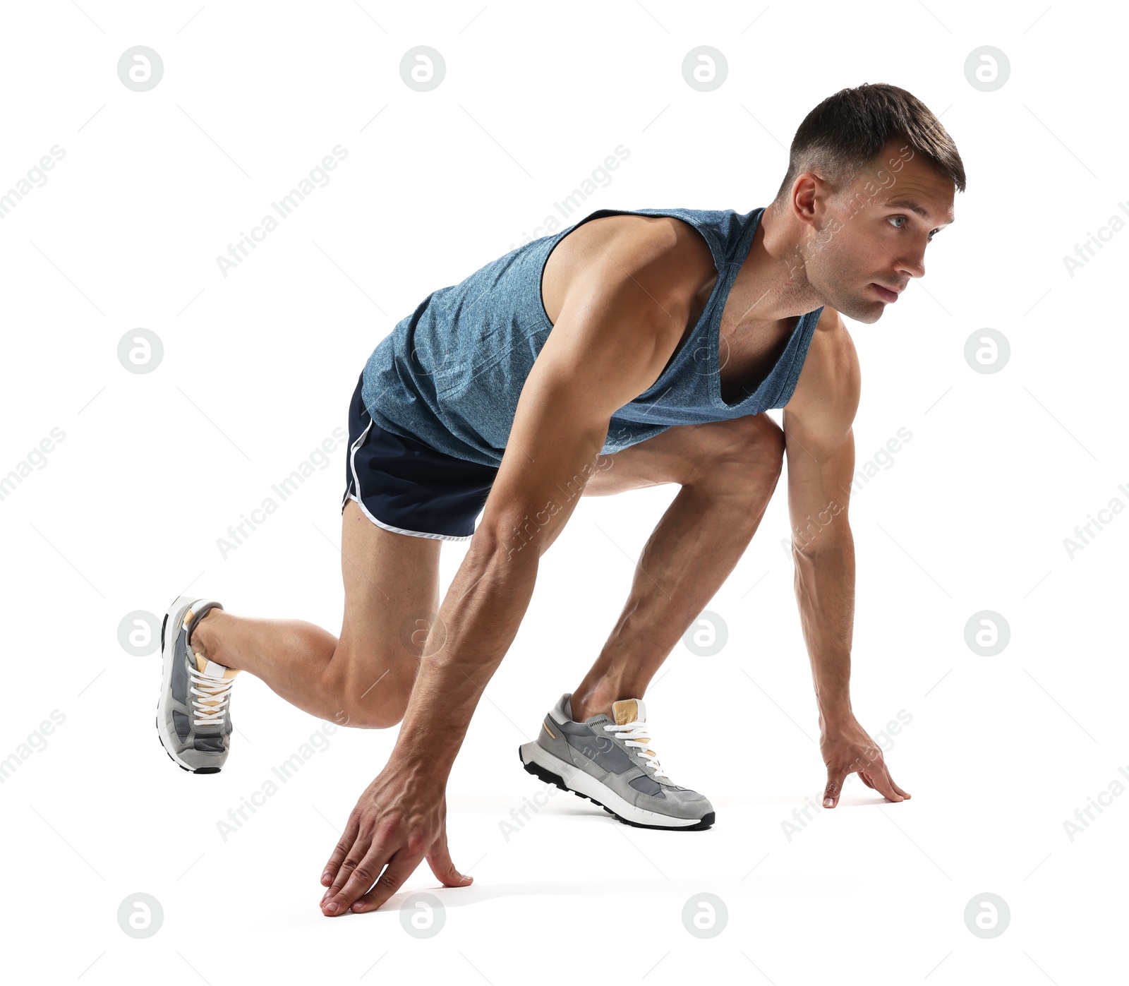 Photo of Sportsman in starting position for run on white background