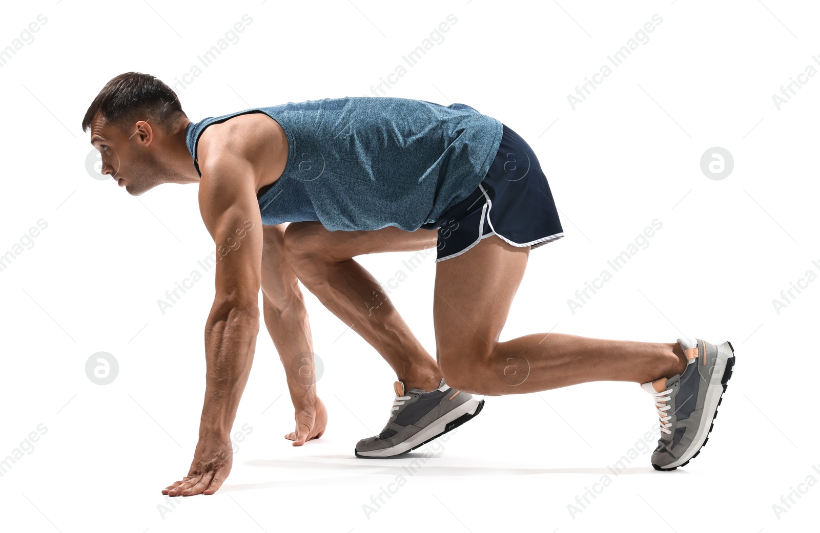 Photo of Sportsman in starting position for run on white background