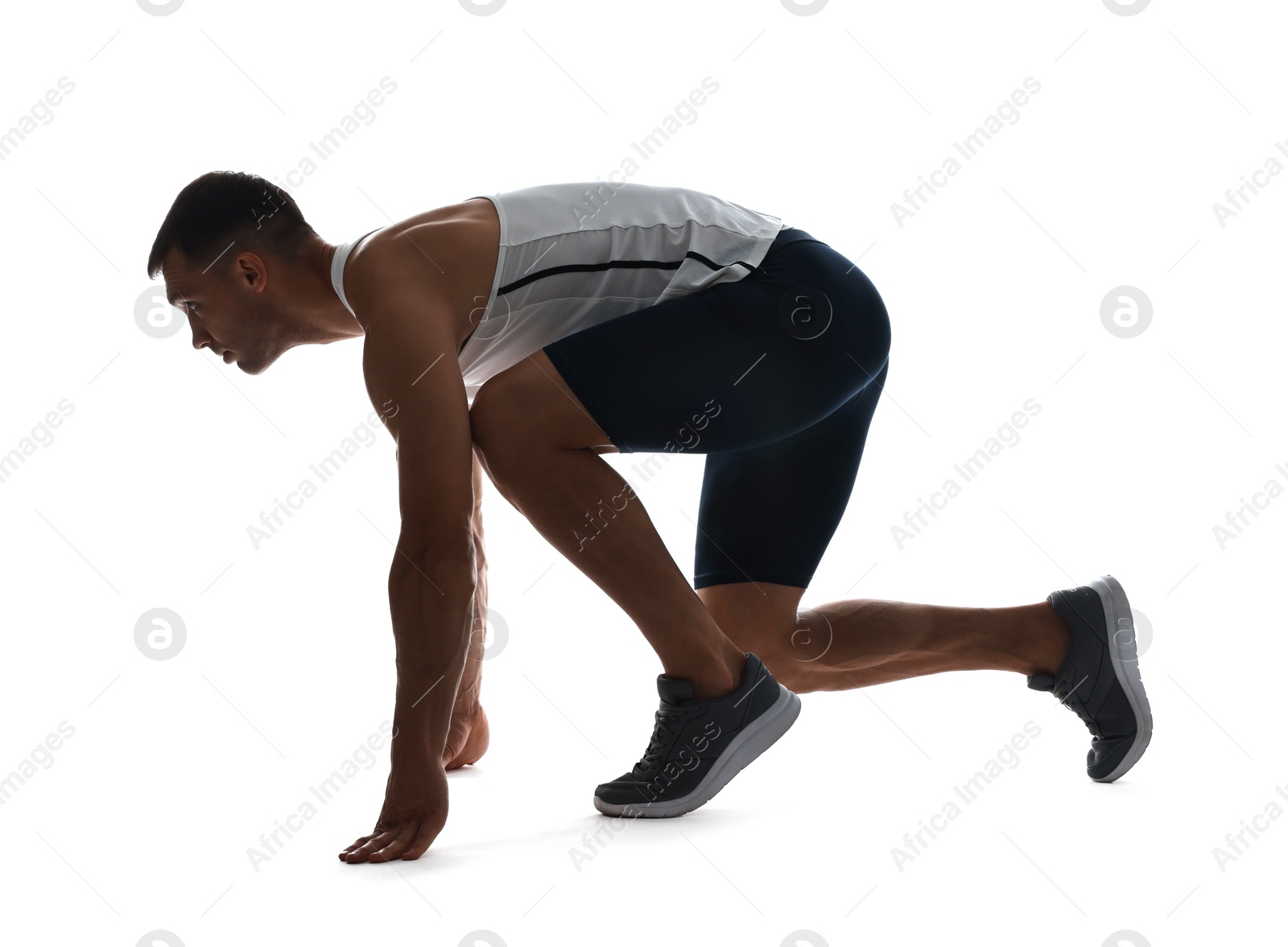 Photo of Sportsman in starting position for run on white background