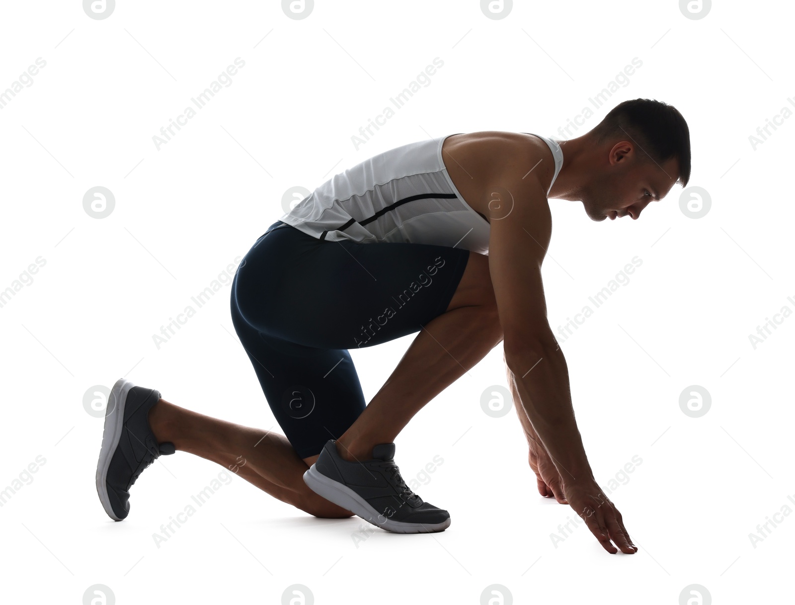 Photo of Sportsman in starting position for run on white background