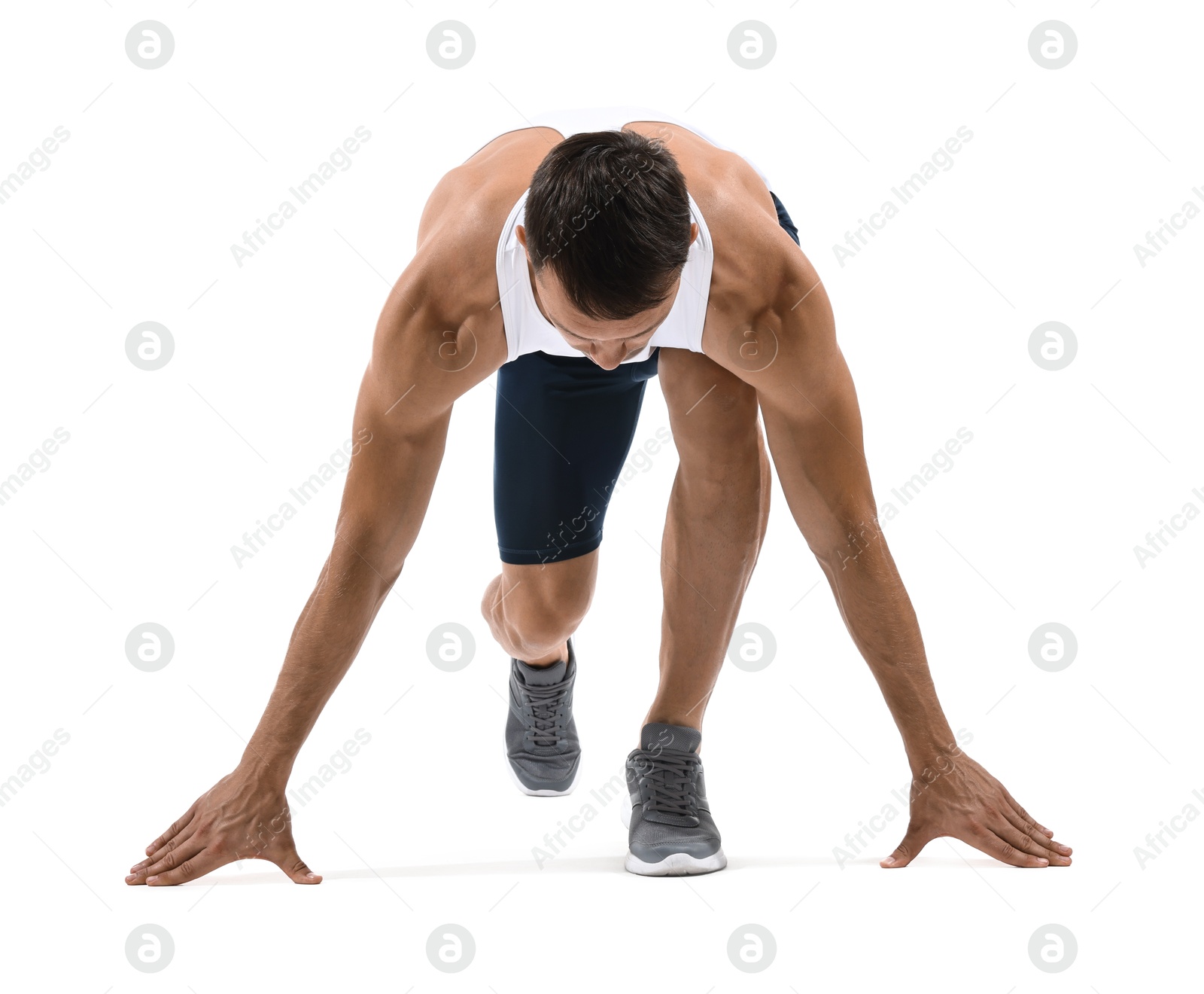 Photo of Sportsman in starting position for run on white background