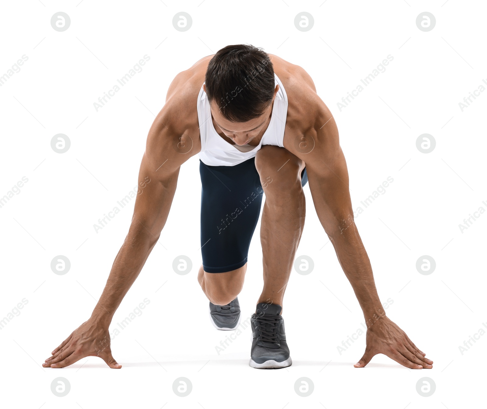 Photo of Sportsman in starting position for run on white background