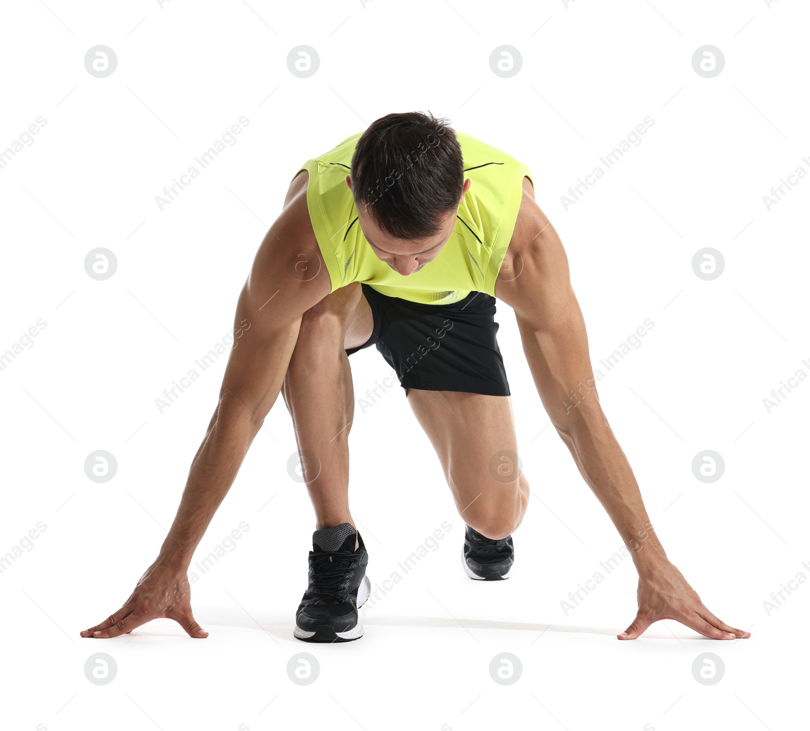 Photo of Sportsman in starting position for run on white background