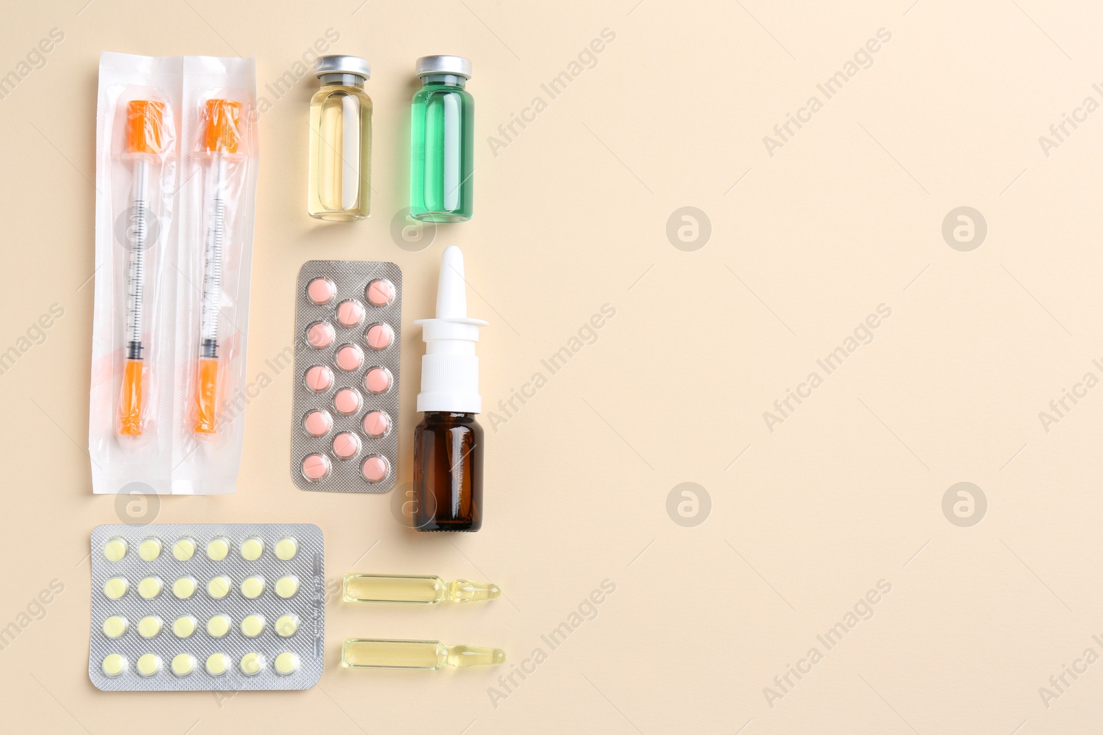 Photo of Pharmacist concept. Flat lay composition with vials, syringes and pills on beige background, space for text