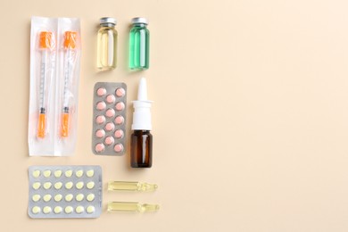 Photo of Pharmacist concept. Flat lay composition with vials, syringes and pills on beige background, space for text