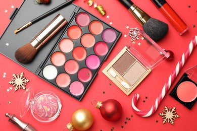 Photo of Flat lay composition with makeup products and Christmas decor on red background