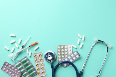 Pharmacist. Many different pills, stethoscope and syringes on light blue background, flat lay