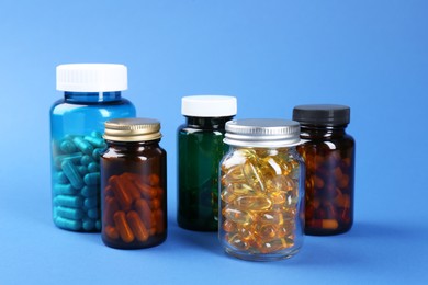 Photo of Pharmacist. Different pills in plastic bottles on blue background