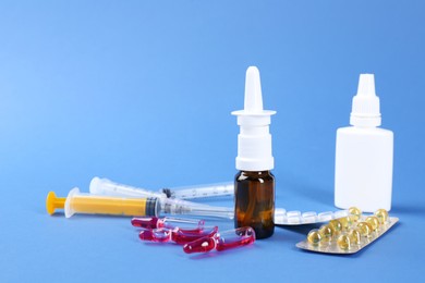 Pharmacist. Bottles of medical drops, pills ampoules and syringes on blue background