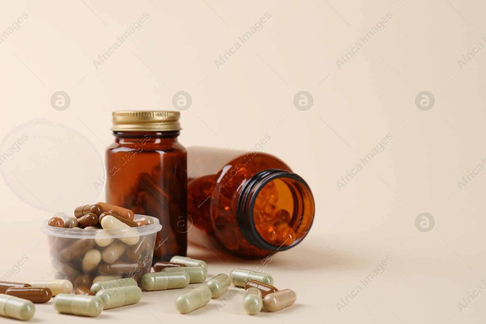 Photo of Pharmacist. Many different pills in plastic container and bottles on beige background, space for text